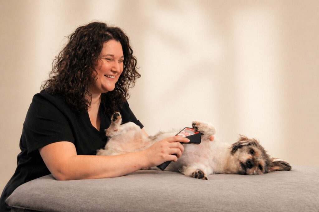 Lena Rummenholl behandelt ihren Therapiebegleithund Snickers mit dem Lasergerät