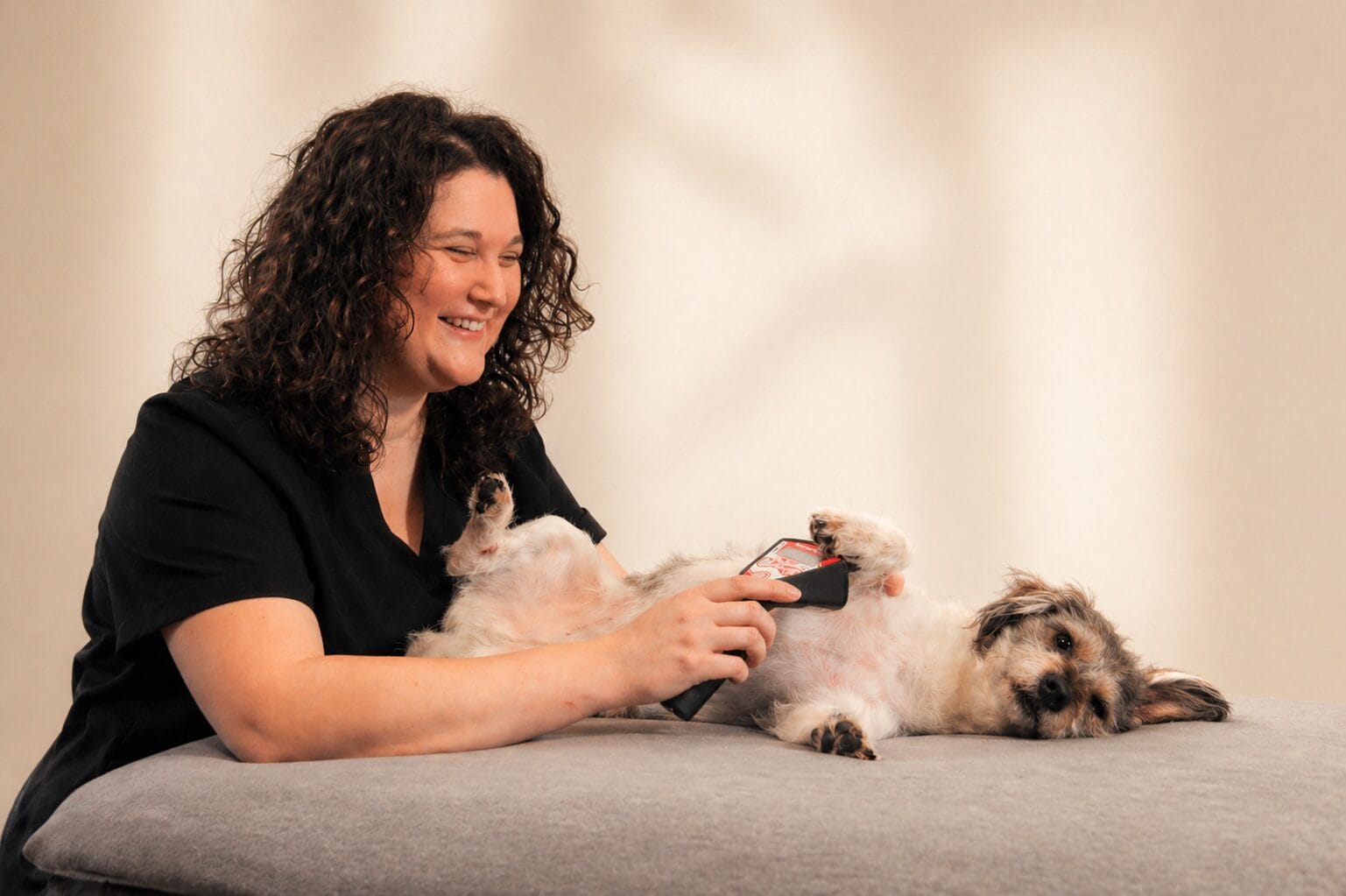 Lena Rummenholl behandelt ihren Therapiebegleithund Snickers mit dem Lasergerät